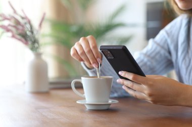 Evde telefon karıştırıcı kahve kullanan bir kadının elini kapat.