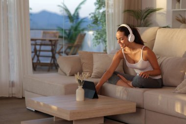 Yogi evde bir tabletle yoga dersi hazırlıyor.