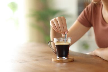 Evdeki ahşap masada kahveyi karıştıran bir kadının eli, sınırsız fotokopi aletiyle kapanır.