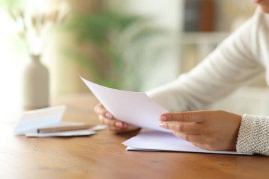 Evin içinde, ahşap bir masanın üzerinde el yazısı yazan bir kadının fotoğrafını çek.