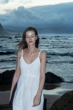 Kumsalda dizüstü bilgisayar kullanan genç bir kadın. Serbest çalışma kavramı