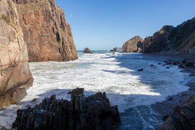Amazing view of grassy rocky cliffs by the cantabrian sea with violent waves, asturias, spain