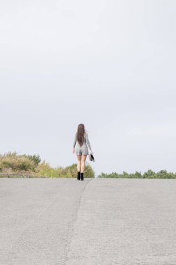 Kendine güvenen Esmer Kadın Bir Yol Uzağında Adımlar, Gösterişli Kısa Elbiseli