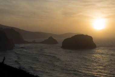 Altın Saat Parlaklığı: Okyanusun Üzerinde Günbatımı Rocky Cliffs Standing Guard