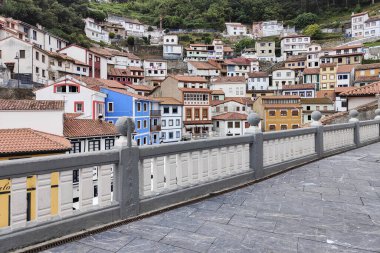 Canlı tepe kenti, bulutlu gökyüzünün altında çeşitli stil ve renkli evler.