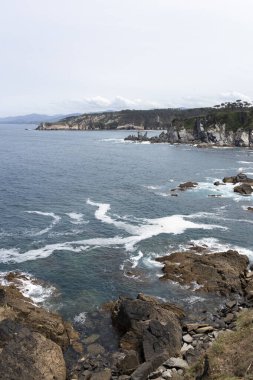 Kayalık sahil şeridi ve arka planda kayalıklar güneşli bir günde yüksek bir noktadan çekildi.