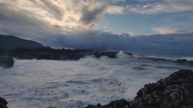 Güçlü Atlantik Okyanusu 'nun çarpıcı, fırtınalı gökyüzüyle buluştuğu engebeli bir Asturian kıyısı.