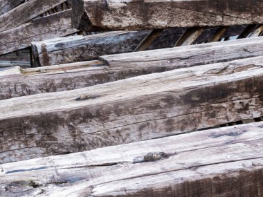 Yığınla yıpranmış ahşap kirişlere yakın çekim.