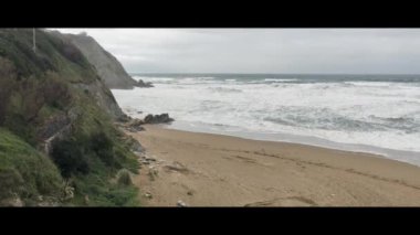 Altın dalgalar Sopelana Sahili 'nin engebeli uçurumlarına çarpıyor. Sörfçüler ve doğa severler için huzurlu bir cennet.