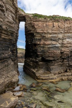 Itzurun plajında, Zumaia 'da, Bask ülkesinde deniz üzerinde doğal bir kemeri olan Flysch uçurumları.