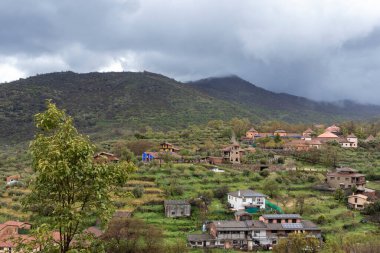 Geleneksel evler, Gran Canaria 'daki büyüleyici bir vadinin manzarasını, bulutlu bir gökyüzünün dramatik varlığı altında noktalarlar.