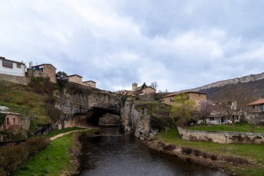 Puentedey köyünün manzaralı manzarası doğal bir kaya köprüsünün üstüne inşa edilmiş, altından akan bir nehir burgos, İspanya