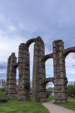 Merida, Extremadura ve İspanya 'da bulutlu gökyüzüne yükselen Roma tarzı kemerlerle Los Milagros su kemeri