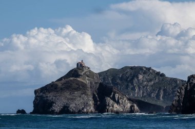San Juan de Gaztelugatxe 'nin manzarası, Bermeo, İspanya' da kayalık bir adanın tepesine tünemiş büyüleyici bir inziva yeri, uçsuz bucaksız Cantabrian denizi ve bulutlu gökyüzü.