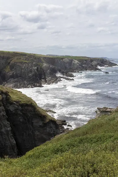 İngiltere, Cornwall 'daki kayalık sahile çarpan engebeli kayalıkların ve güçlü dalgaların manzarası dramatik bir kıyı manzarası yaratıyor.