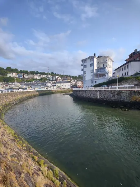 Serene nehri berrak mavi gökyüzünün altında büyüleyici bir kıyı kasabasında kıvranıyor, huzurlu ve manzaralı bir manzara sunuyor.