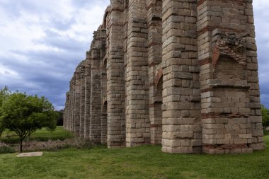 Merida 'daki etkileyici antik Roma su kemeri los milagros, Extremadura, İspanya, bulutlu gökyüzüne karşı yıpranmış tuğla kemerleri
