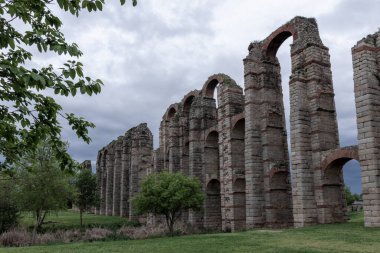 Merida, İspanya 'daki Los Milagros su kemeri bulutlu bir gökyüzüne karşı kemer ve tuğla sütunlarla antik Roma mimarisini sergiliyor.