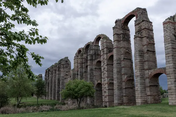 Merida, İspanya 'daki Los Milagros su kemeri bulutlu bir gökyüzüne karşı kemer ve tuğla sütunlarla antik Roma mimarisini sergiliyor.