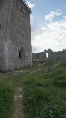 Bulutlu gökyüzünün altında kulesi olan antik taş kale