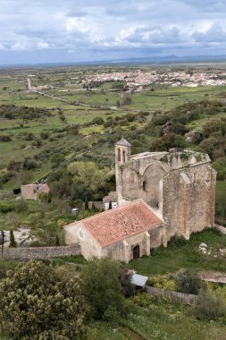 Turuncu çatısı ve yeşil vadiye bakan çan kulesi ile yıkılmış kilise ve Cuenca, İspanya 'daki Belmonte kasabası.