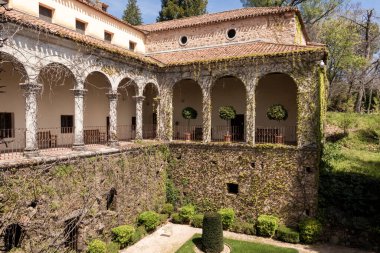 Yuste manastırı. Kemerleri, sütunları, fayanslı çatısı ve güneşli bir günde bahçesi var.