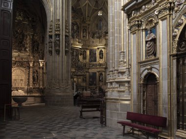 Büyük Astorga Katedrali 'nin içinde ön planda boş banklar olan altın sunak ve heykel süsleyin.