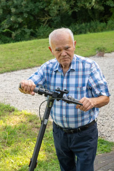 Starszy Mężczyzna Pewnie Jeździ Skuterze Pokazując Mieszankę Nowoczesnej Technologii Wdziękiem Zdjęcie Stockowe