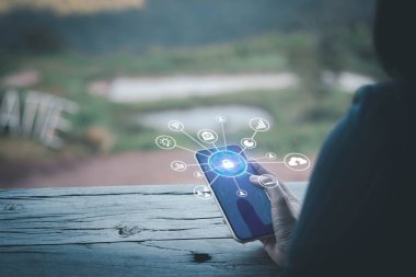 İş kadını, ağ güvenlik simgesiyle akıllı telefon tutuyor. Güvenlik ağı güvenlik bilgisayarınızı koruyun ve veri konseptinizi, siber güvenliği ve tehlikelere karşı korumanızı sağlayın. Kalite Güvencesi