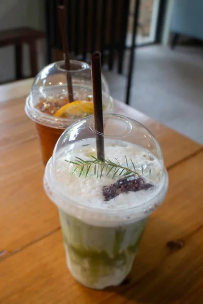 Iced green tea with milk and iced lemon tea on wooden table, stock photo