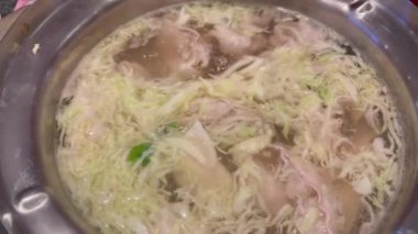 Sukiyaki ya da shabu yapmak için sıcak bir tencerede yemek pişirmek.
