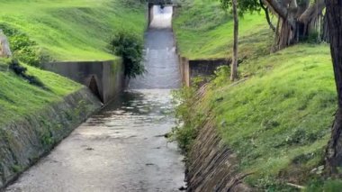 Altında beton banka takviyesi ve su olan kırsal bir yol, stok görüntüleri.
