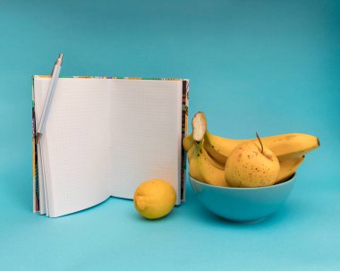 mavi arkaplanda meyve ve defter