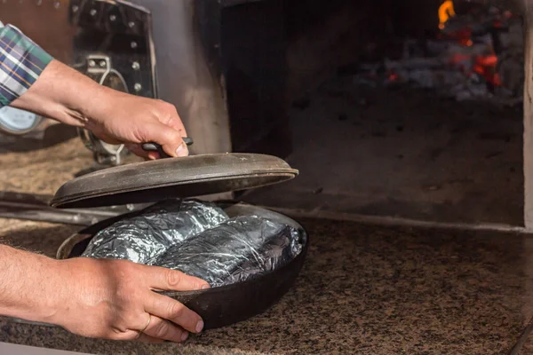男は熱いオーブンで肉とフライパンを置きます 料理のレシピ — ストック写真