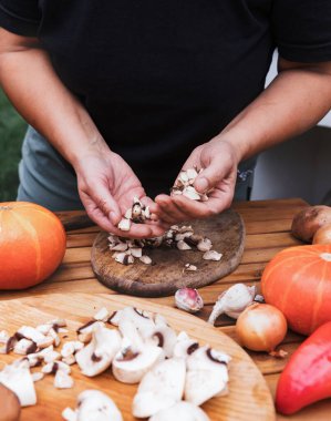 Kadınların elleri doğranmış şampiyonları tutar. Cadılar bayramı için balkabaklarını hazırlama süreci. Sebze yemeği tarifi. Fotoğraf serisi