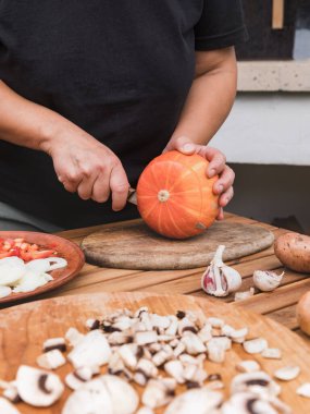 Balkabağı kesiyorum. Düşen balkabağı tarifi yapma süreci. Balkabağının yanında mantar, soğan, dolmalık biber ve sarımsak var. Fotoğraf serileri