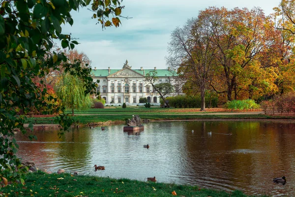 ワルシャワのクラシンスキー宮殿 バロック様式の宮殿を再建 現在はポーランド国立図書館特別コレクション部門の一部となっている 公園の側面と池からのファサードの眺め — ストック写真