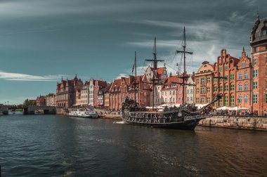 Gdansk 'taki Motlawa Nehri' nin seti. Eski tuğla evler ve vinç. Nehrin diğer tarafındaki modern evler.