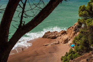 Calella 'daki Roca Pins plajı. Kayaların arasında pitoresk bir sahil. İspanya 'da Akdeniz kıyısında. Costa del Maresme. Barselona yakınlarında bir sahil.