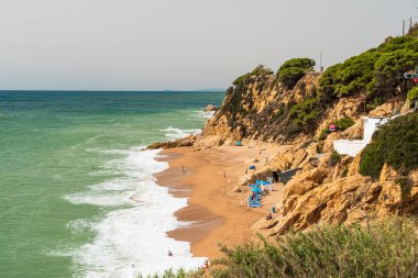 Calella 'daki Roca Pins plajı. Kayaların arasında pitoresk bir sahil. İspanya 'da Akdeniz kıyısında. Costa del Maresme. Barselona yakınlarında bir sahil.