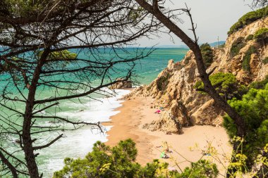 Calella 'daki Roca Pins plajı. Kayaların arasında pitoresk bir sahil. İspanya 'da Akdeniz kıyısında. Costa del Maresme. Barselona yakınlarında bir sahil.