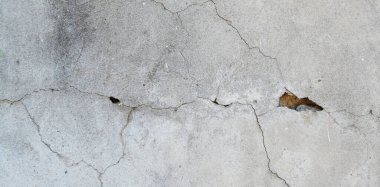 Çatlak duvar dokusu. Arka plan olarak çimento yüzeyi ile kaplı çatlamış beton duvar. Çizik ve çatlaklarla dolu bir duvar parçası.