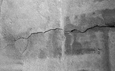 Duvar dokusu arka planı. Çatlak duvar dokusu. Arka plan olarak çimento yüzeyi ile kaplı çatlamış beton duvar. Çizik ve çatlaklarla dolu bir duvar parçası..