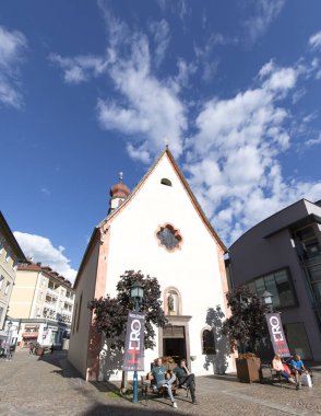 Ortisei, İtalya - 13 Haziran 2024: Ortisei 'deki Aziz Antonius Kilisesi önündeki turistlere bakış