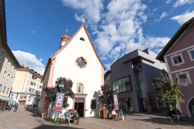 Ortisei, İtalya - 13 Haziran 2024: Ortisei 'deki Aziz Antonius Kilisesi önündeki turistlere bakış