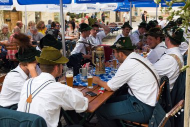 Mittenwald, Almanya - 31 Mayıs 2018: Geleneksel kostümlü gençler Bavyera 'da düzenlenen yerel bir ziyafet sırasında bira içip sohbet ediyorlar
