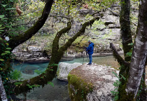 Kalarrytes, Yunanistan - 2 Ekim 2019: Bir adam Tzoumerka dağlarındaki bir şelalenin fotoğraflarını çekiyor