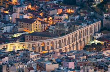 Panoramic view of the Roman aqueduct and part of the city of Kavala in eastern Greece at night clipart