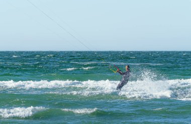 İnsanlar açık güneşli bir günde açık denizde ya da okyanus kıyısında uçurtma kampında güneş altında sörf yapmaya bayılırlar. Watersport adrenalin eğlence macera keskinliği