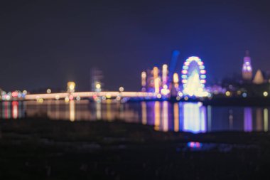 Hollanda 'da nehir boyunca uzanan eski şehrin (Kampen) Nightscape' i bir dönme dolabın ışıklandırılması ve bir yelkenli etkinliği ile